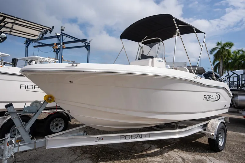 Slide: The Image of 2024 Robalo R180 boat on trailer, white hull, outdoor display. - 14
