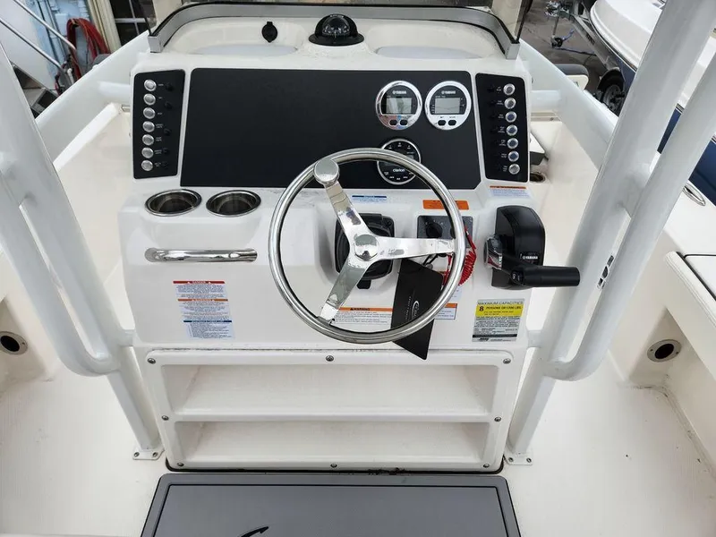 Slide: The Image of 2023 Robalo 226 Cayman boat dashboard with steering wheel and controls. - 4