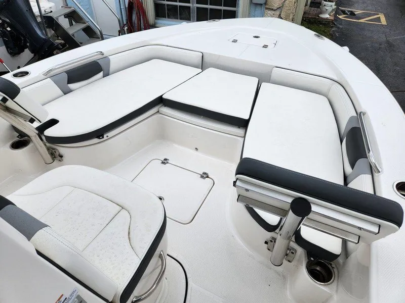 Slide: The Image of 2023 Robalo 226 Cayman boat interior with white cushioned seating and storage compartments. - 5