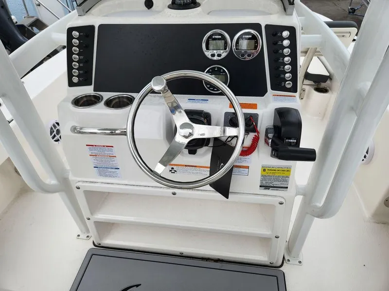 Slide: The Image of 2023 Robalo 226 Cayman boat dashboard with steering wheel and controls. - 6