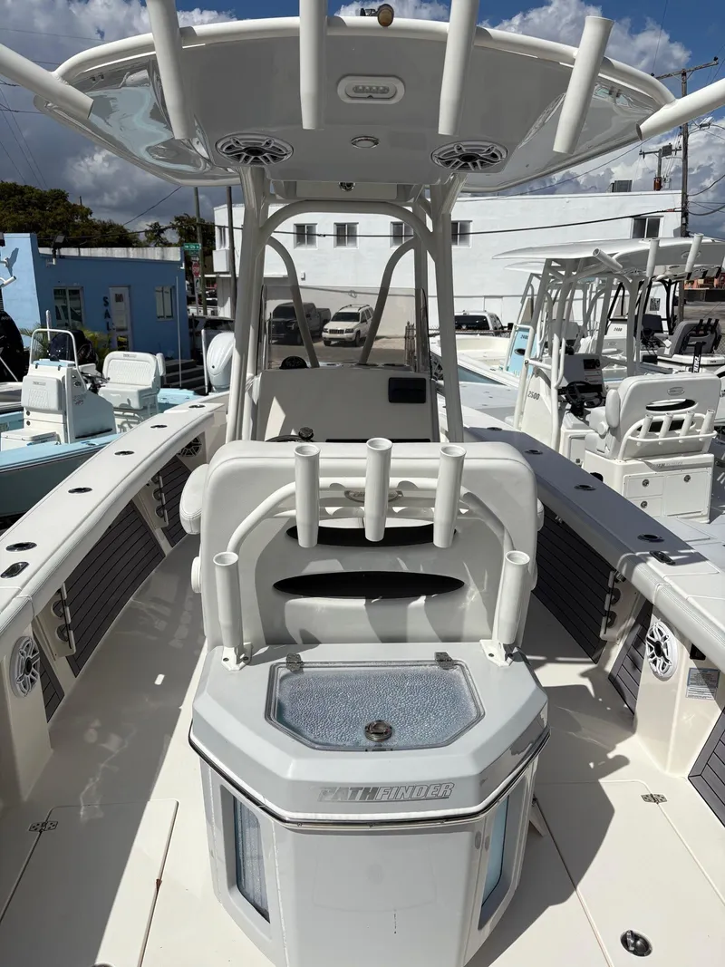 Slide: The Image of 2024 Pathfinder 2700 Open boat interior with rod holders and seating, under a clear blue sky. - 4