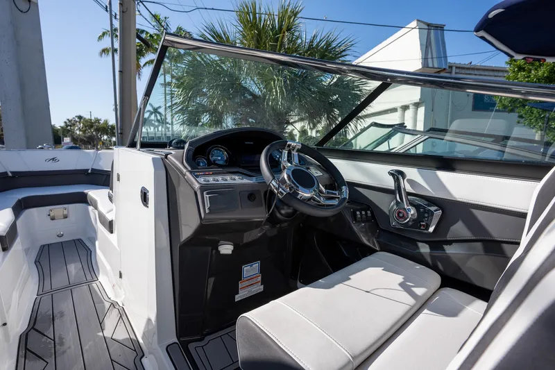 Slide: The Image of 2023 Monterey 275SS boat cockpit with modern steering and controls, featuring sleek design. - 13
