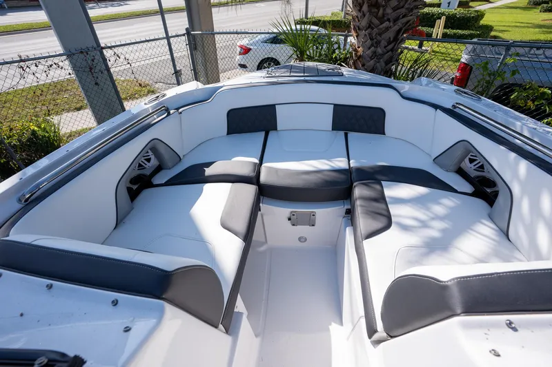 Slide: The Image of 2023 Monterey 275SS boat interior with white and gray seating, outdoor setting. - 22