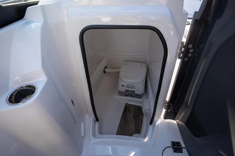 Slide: The Image of 2023 Monterey 275SS boat interior with compact marine toilet and sleek design. - 25