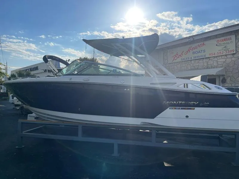 Slide: The Image of 2023 Monterey 275SS boat displayed at dealership under sunny sky. - 26