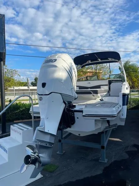 Slide: The Image of 2023 Monterey 275SS boat with outboard motor, displayed outdoors under a partly cloudy sky. - 3