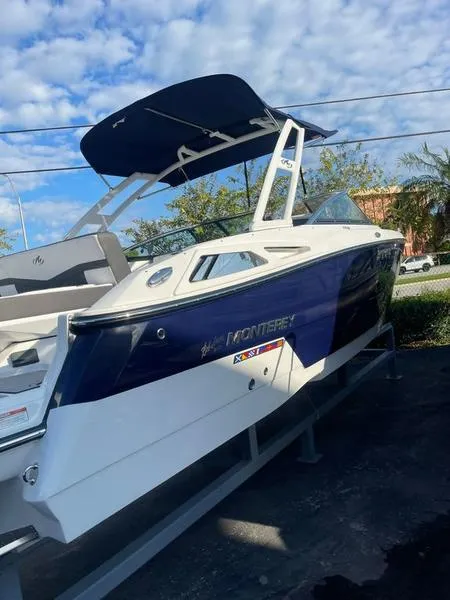 Slide: The Image of 2023 Monterey 275SS boat with blue and white design, docked outdoors under a blue sky. - 4
