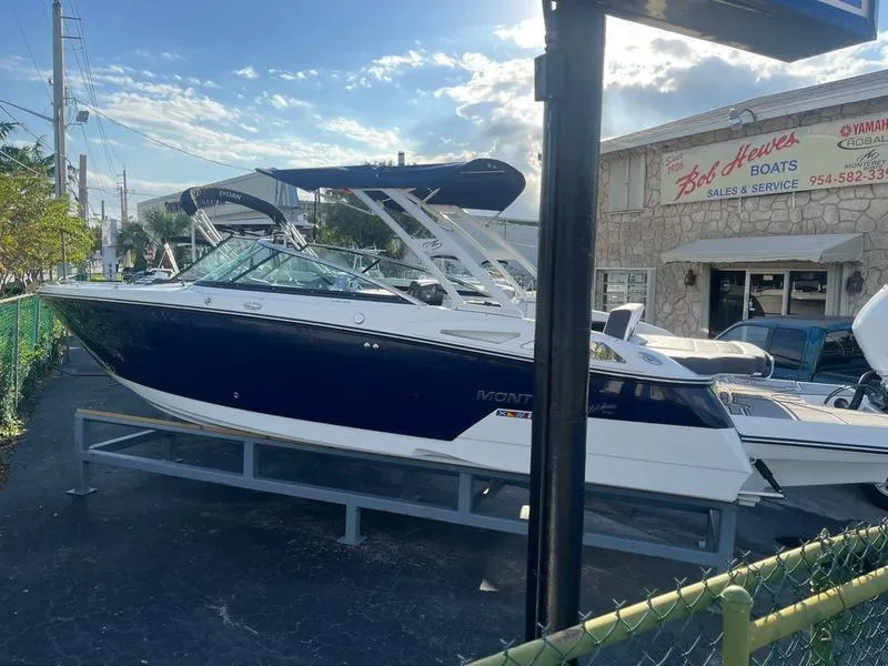 Slide: The Image of 2023 Monterey 275SS boat displayed at a dealership under a clear blue sky. - 5