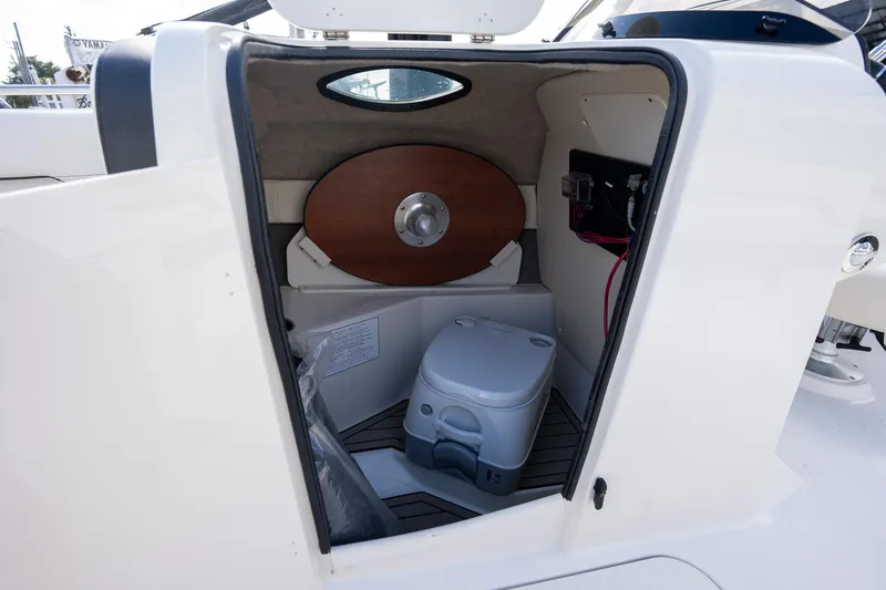 Slide: The Image of 2024 Stingray 212SC boat interior with compact toilet and storage space. - 10