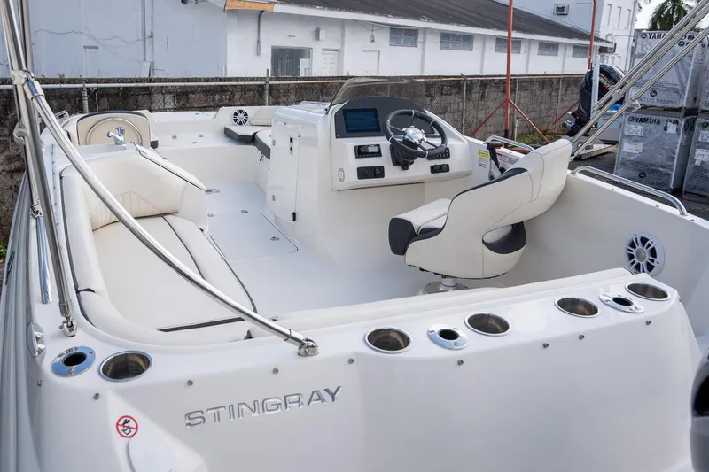 Slide: The Image of 2024 Stingray 212SC boat interior with helm, seating, and cup holders. - 12