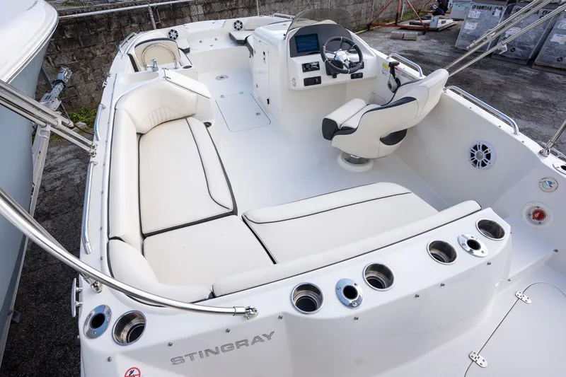 Slide: The Image of 2024 Stingray 212SC boat interior with white seating and modern helm controls. - 13