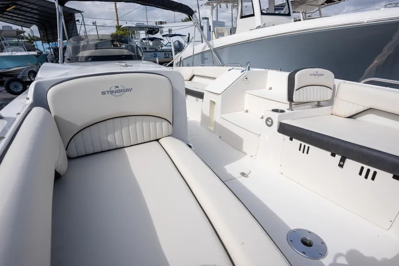 Slide: The Image of 2024 Stingray 212SC boat interior with white seating and modern design. - 5