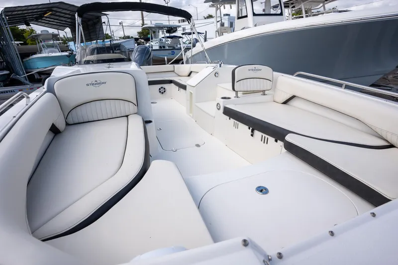 Slide: The Image of 2024 Stingray 212SC boat interior with white seating and modern design. - 6