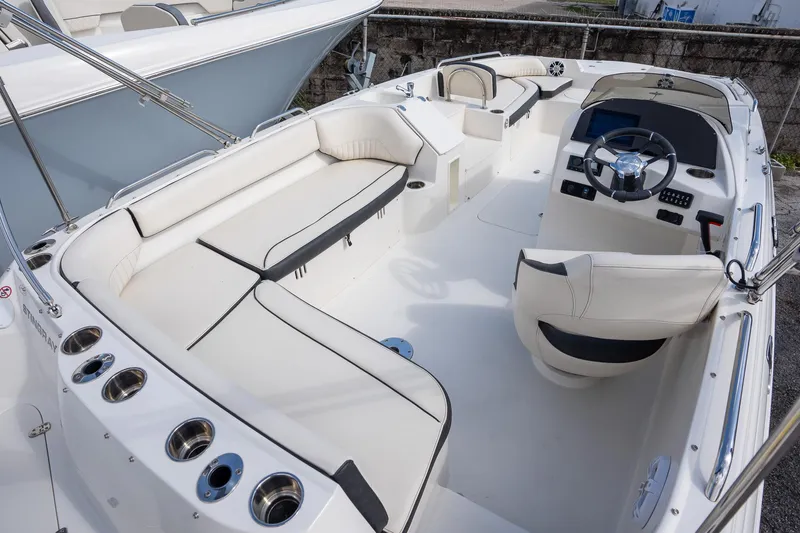 Slide: The Image of 2024 Stingray 212SC boat interior with white seating and modern dashboard. - 8