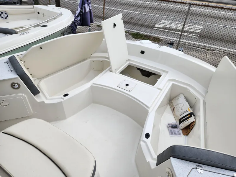 Slide: The Image of 2023 Stingray 206cc boat interior with open storage compartments and seating. - 12