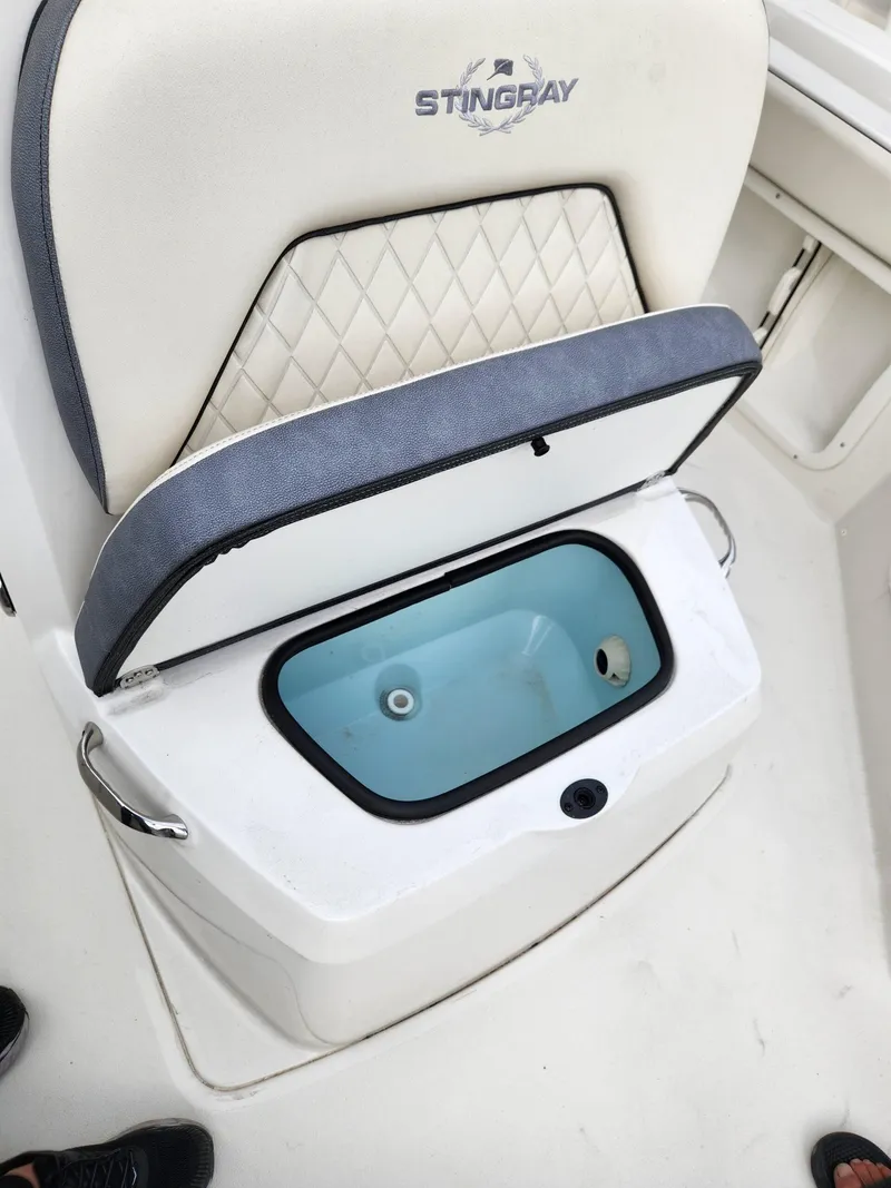 Slide: The Image of 2023 Stingray 206cc boat seat with built-in storage compartment open. - 15