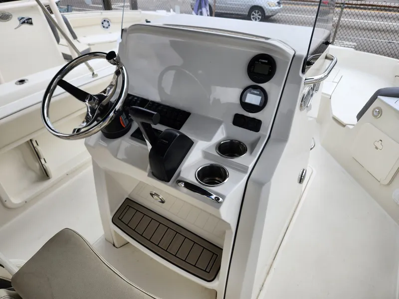 Slide: The Image of 2023 Stingray 206cc boat console with steering wheel, controls, and cup holders. - 17