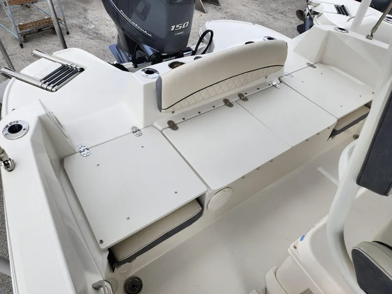 Slide: The Image of 2023 Stingray 206cc boat interior with Yamaha 150 engine, featuring white seating and storage. - 18