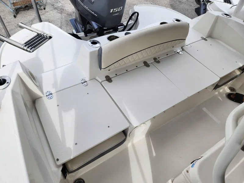 Slide: The Image of 2023 Stingray 206cc boat interior with Yamaha 150 engine, featuring white seating and deck. - 25