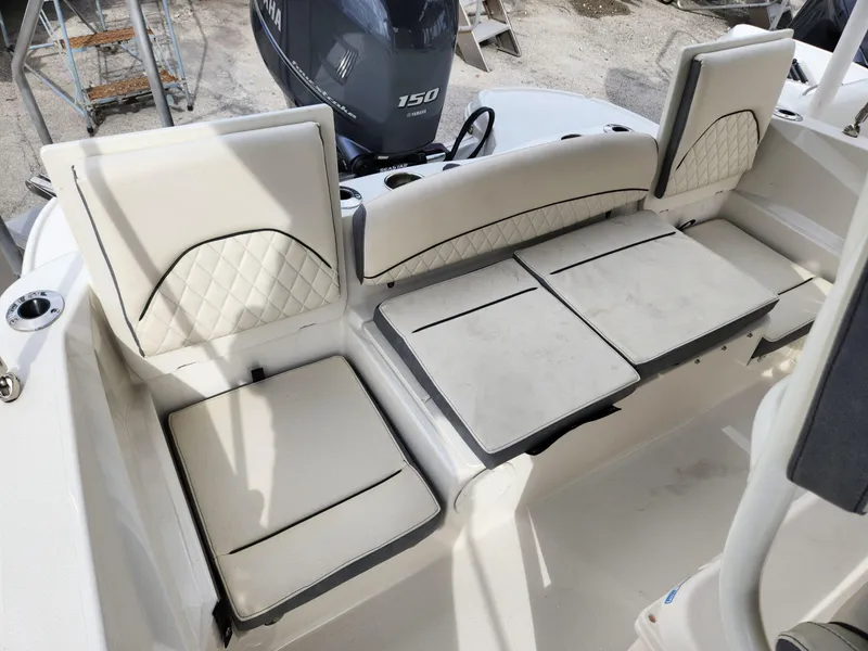 Slide: The Image of 2023 Stingray 206cc boat interior with white cushioned seating and Yamaha 150 engine. - 26