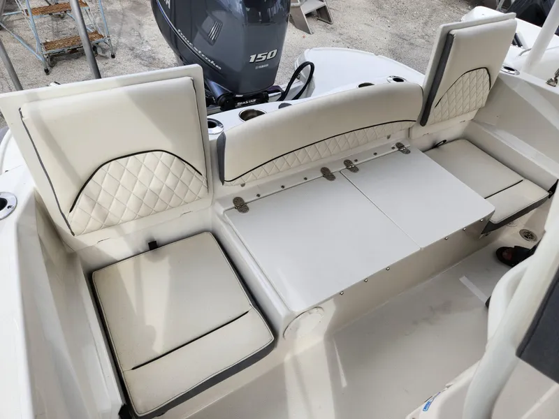 Slide: The Image of 2023 Stingray 206cc boat interior with white cushioned seating and Yamaha 150 engine. - 27