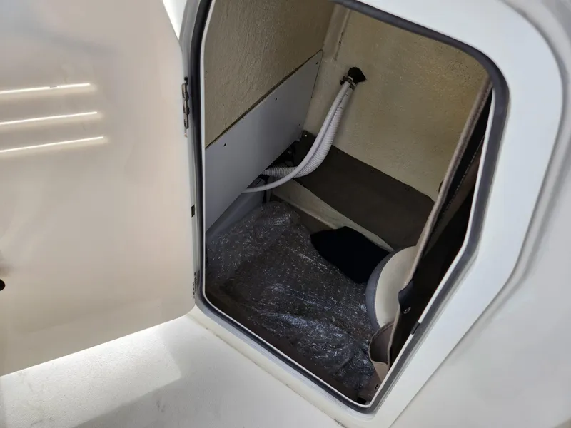 Slide: The Image of Interior cabin of 2023 Stingray 206cc boat, featuring storage space and seating. - 29