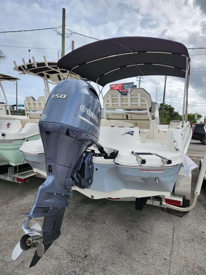Slide: The Image of 2023 Stingray 206cc boat with Yamaha 150 outboard motor, parked on a trailer. - 3