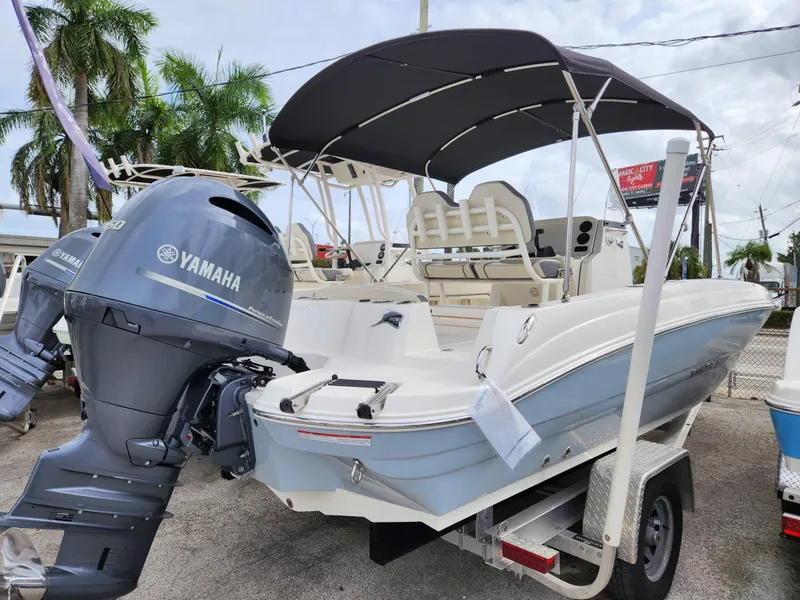 Slide: The Image of 2023 Stingray 206cc boat with Yamaha engine, parked on a trailer, under a canopy. - 4