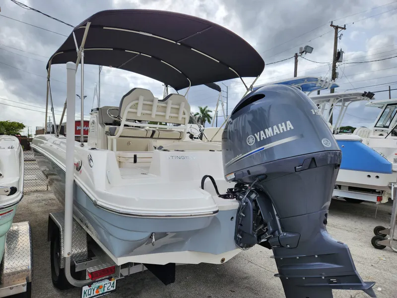 Slide: The Image of 2023 Stingray 206cc boat with Yamaha outboard motor, parked on a trailer. - 5