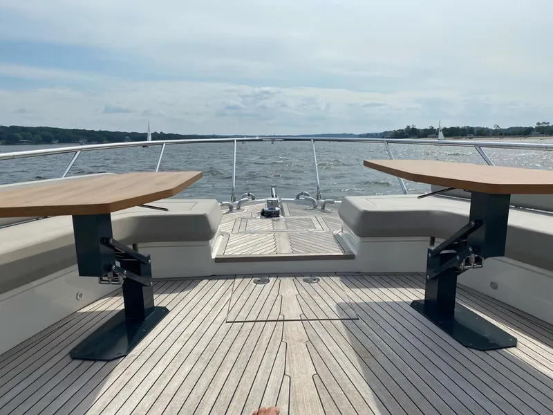 Slide: The Image of Ferretti Yachts 670, 2020 model, featuring spacious deck with seating and tables, on open water. - 9