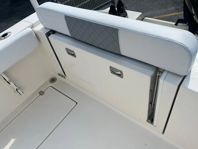 Slide: The Image of 2022 Cobia 237 Center Console boat with white seating and storage compartments. - 11