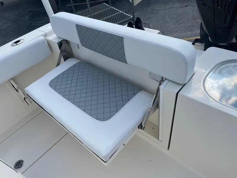 Slide: The Image of 2022 Cobia 237 Center Console boat seat with gray and white cushioned design. - 12