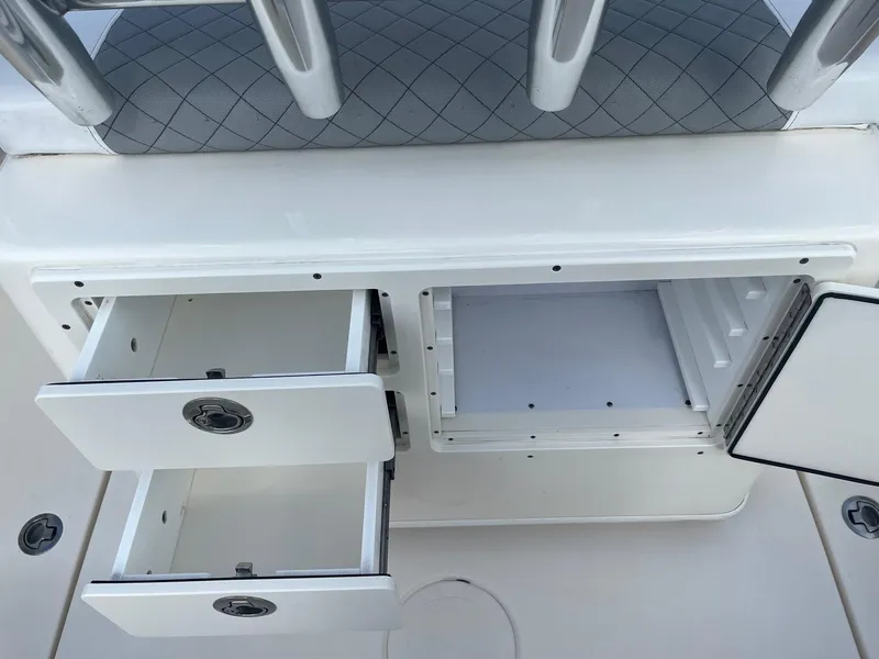 Slide: The Image of 2022 Cobia 237 Center Console storage compartments with open drawers and hatch. - 13