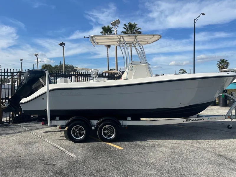 Slide: The Image of 2022 Cobia 237 Center Console boat on trailer in parking lot. - 2