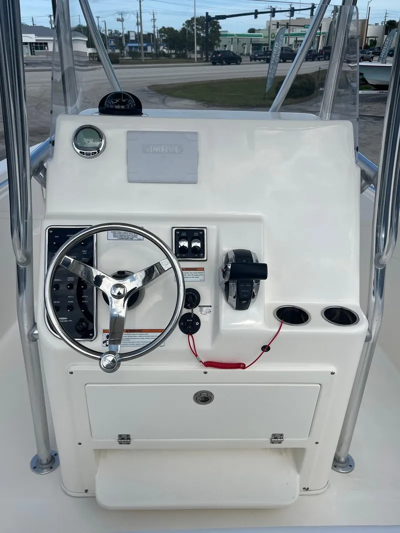 Slide: The Image of 2022 Cobia 237 Center Console boat dashboard with steering wheel and controls. - 5