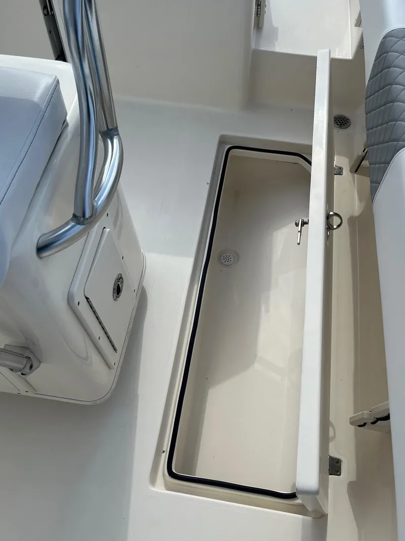 Slide: The Image of 2022 Cobia 237 Center Console boat with open storage compartment. - 9
