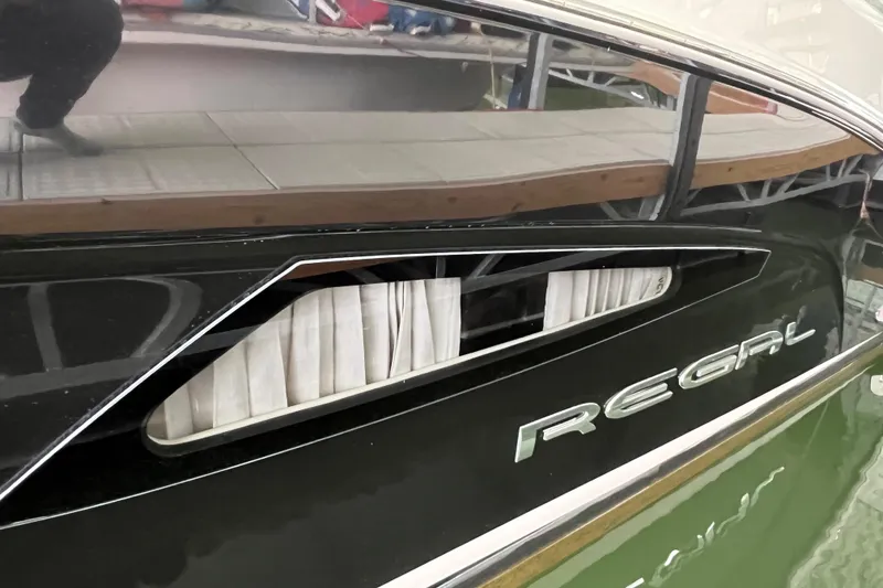 Slide: The Image of 2019 Regal 33 Express boat, sleek black exterior with window and logo detail. - 15