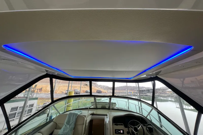 Slide: The Image of 2019 Regal 33 Express boat interior with blue LED lighting and modern cockpit design. - 16