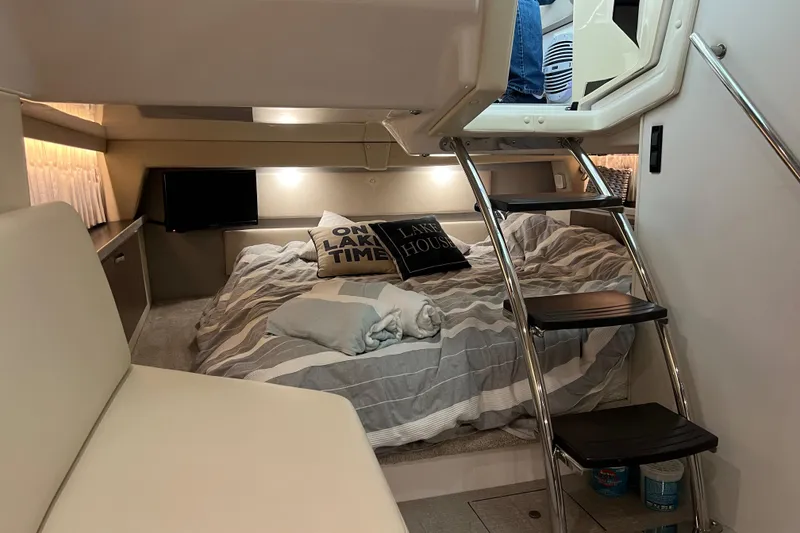 Slide: The Image of 2019 Regal 33 Express cabin interior with bed, stairs, and cozy decor. - 29
