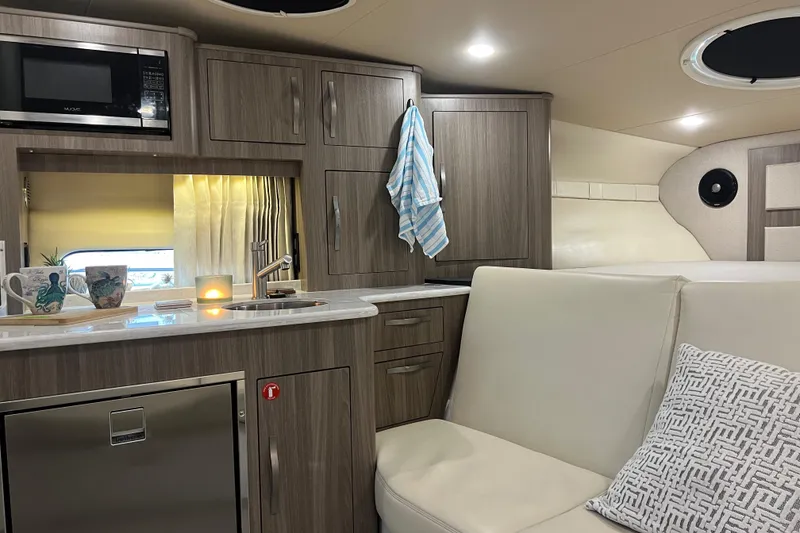 Slide: The Image of 2019 Regal 33 Express yacht interior with modern kitchen, seating, and ambient lighting. - 32