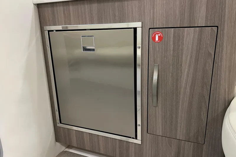 Slide: The Image of 2019 Regal 33 Express interior with stainless steel fridge and wooden cabinetry. - 34