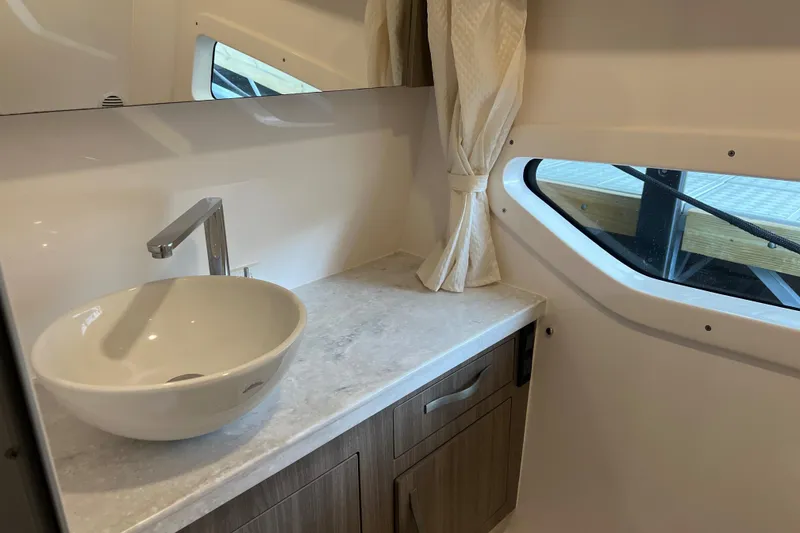 Slide: The Image of 2019 Regal 33 Express bathroom with modern sink, countertop, and window. - 40