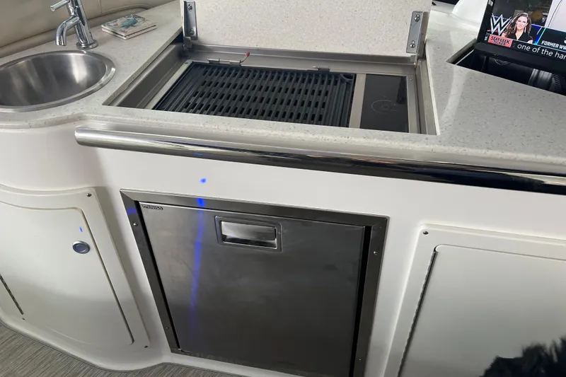 Slide: The Image of 2019 Regal 33 Express yacht kitchenette with sink, grill, and stainless steel fridge. - 44