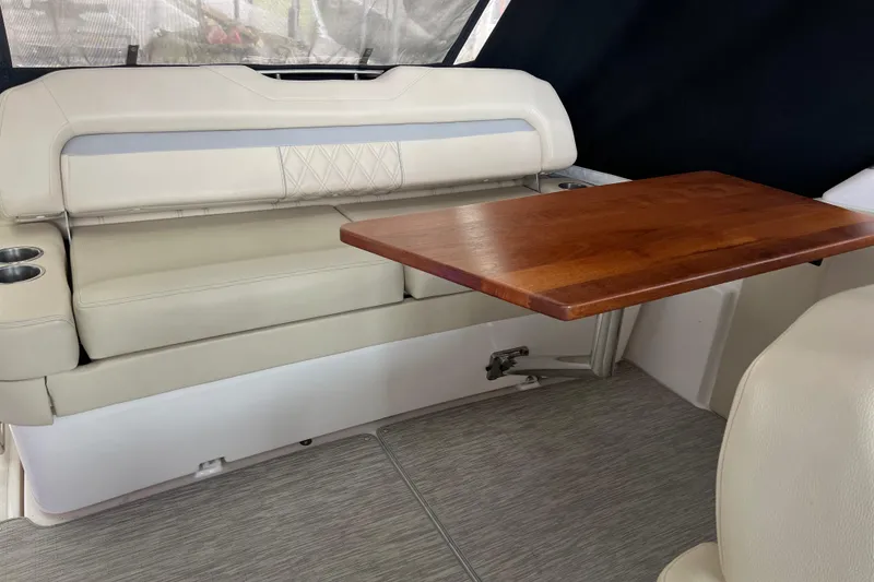 Slide: The Image of 2019 Regal 33 Express interior with beige seating and wooden table. - 48