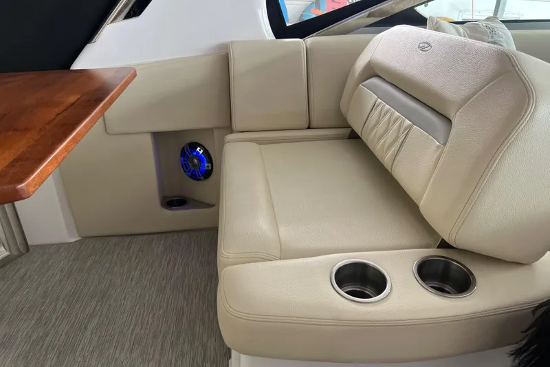 Slide: The Image of 2019 Regal 33 Express boat interior with beige seating and cup holders. - 50