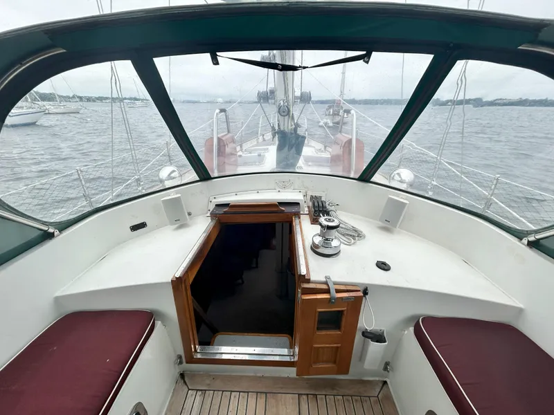Slide: The Image of Cockpit view of 1987 Passport 51 sailboat with open hatch and ocean background. - 10