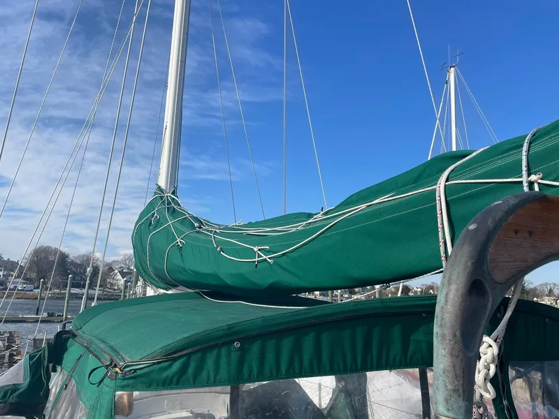 Slide: The Image of Sailboat with green cover and rigging, Passport 51 model, 1987, under clear blue sky. - 2