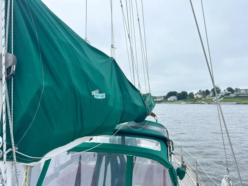 Slide: The Image of Sailboat with green cover on water, Passport 51 model, 1987. - 20