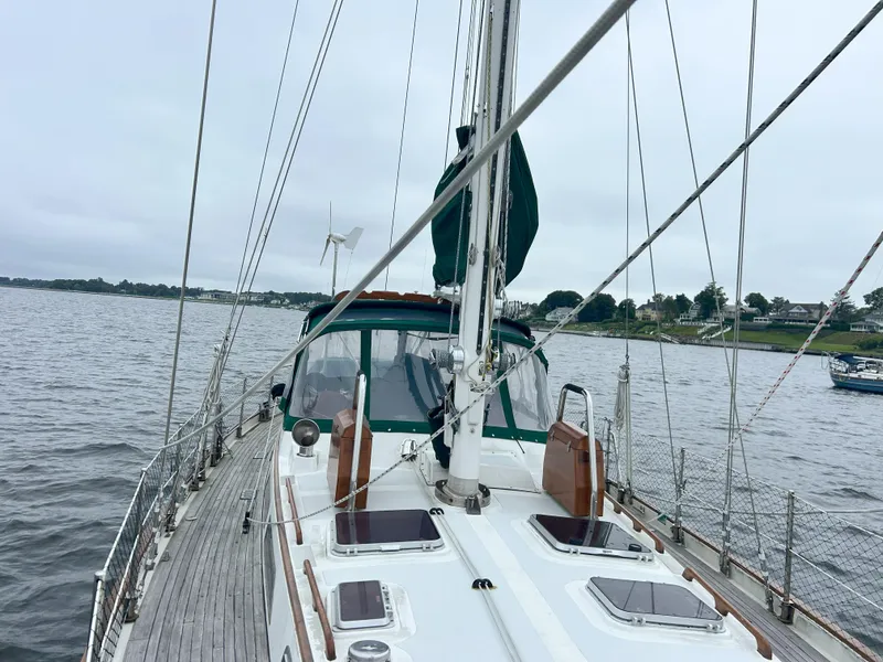 Slide: The Image of Sailboat on calm water, Passport 51 model, 1987, with overcast sky and shoreline view. - 24