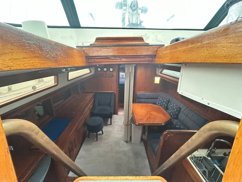 Slide: The Image of Interior of a 1987 Passport 51 sailboat with wooden furnishings and cozy seating area. - 29